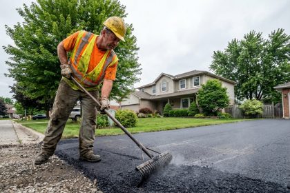 Ouvrier en haute visibilité étalant de l'asphalte frais